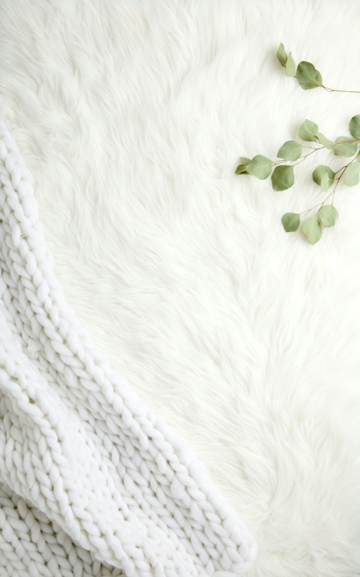 Chunky knit cream throw blanket, draped view