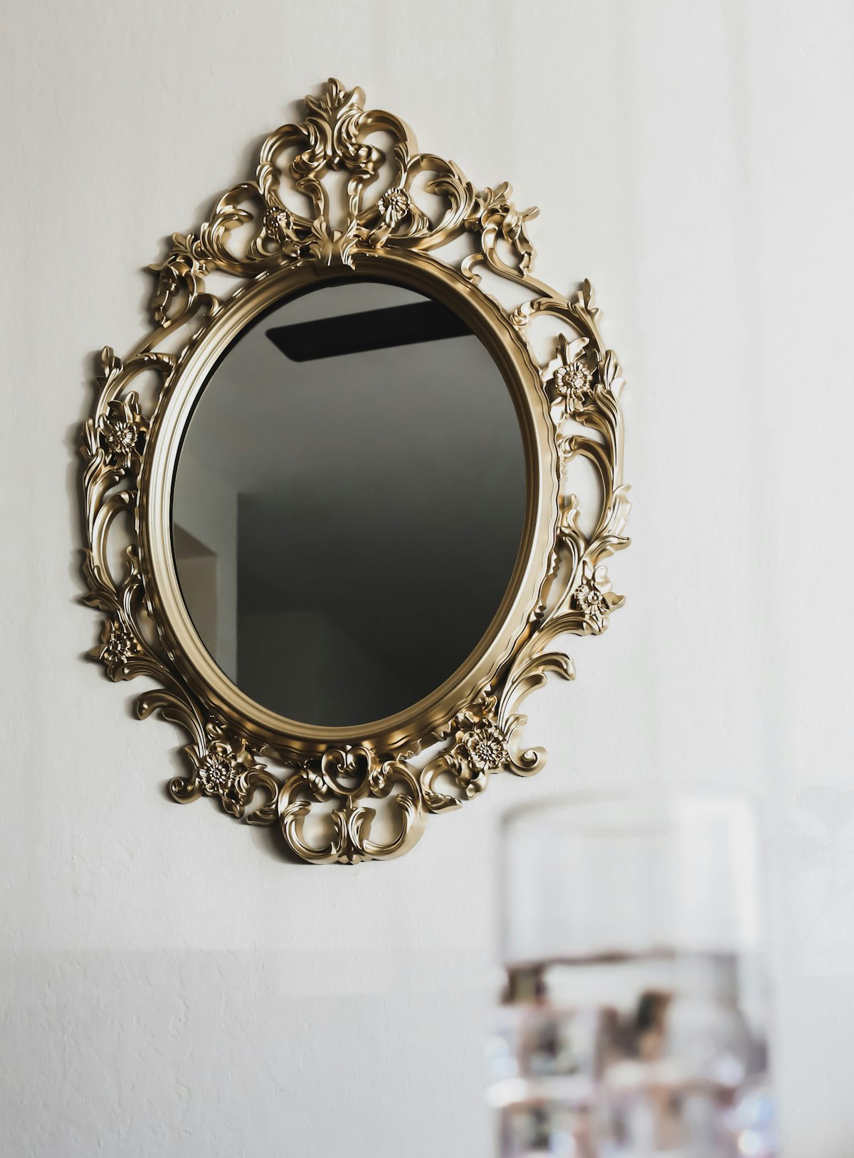 Round gold frame wall mirror, angle view